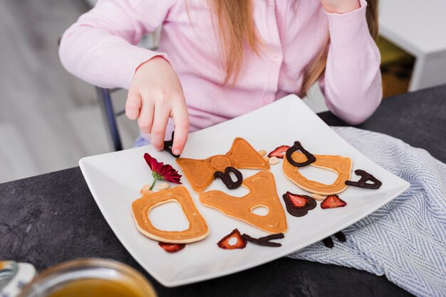 Kleines Mädchen, das Frühstück am Vatertag zubereitet