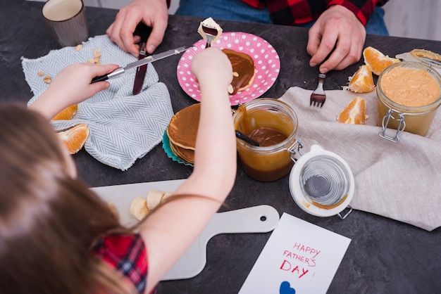 Kleines Mädchen, das Frühstück mit ihrem Vater genießt