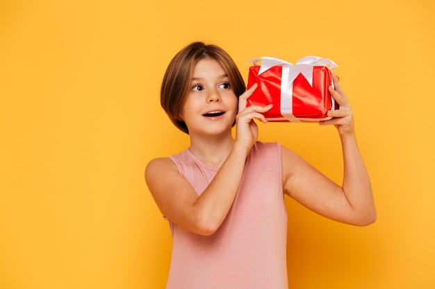 Kleines Mädchen, das Geschenk hält und beiseite schaut