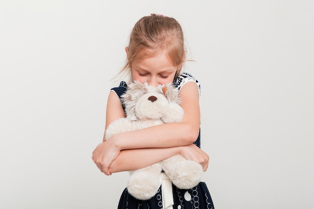 Kleines Mädchen, das ihren Teddybären umarmt