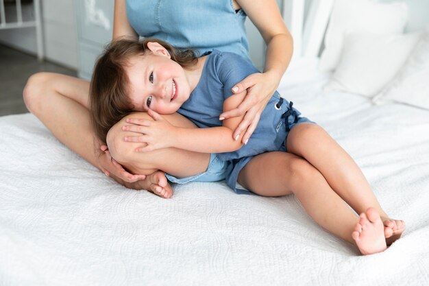 Kleines Mädchen, das mit ihrem Kopf auf dem Schoß ihrer Mutter bleibt