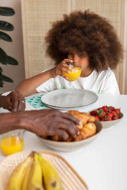 Kostenloses Foto kleines mädchen, das mit ihrem vater frühstückt