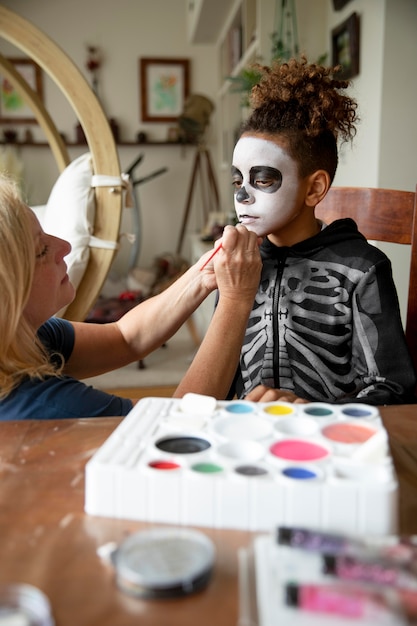 Kleines Mädchen, das sich mit einem Skelettkostüm auf Halloween vorbereitet