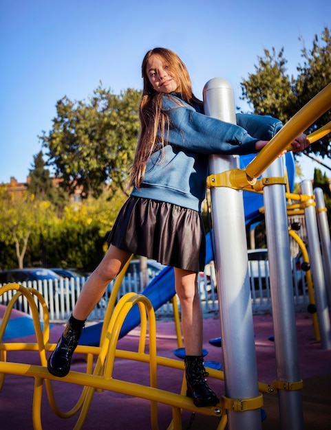 Kleines Mädchen, das Spaß am Spielplatz im Freien hat