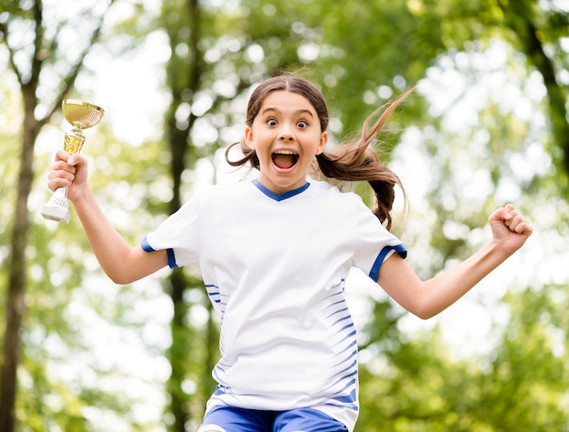 Kleines Mädchen, das springt, nachdem es ein Fußballspiel gewonnen hat