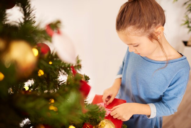 Kleines Mädchen, das Weihnachtsgeschenke vorbereitet