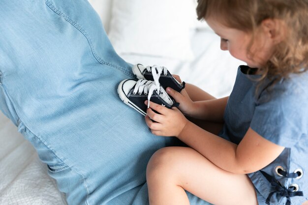 Kleines Mädchen der Nahaufnahme, das mit kleinen Schuhen spielt