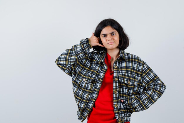 Kleines Mädchen im Hemd, Jacke, die Telefonanrufgeste macht, Vorderansicht.