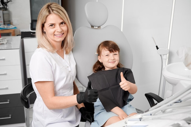 Kleines Mädchen im Zahnarztstuhl während des Untersuchungsprozesses