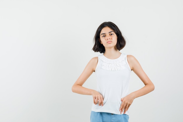 Kleines Mädchen in der weißen Bluse, Shorts, die vorne schauen und müde schauen, Vorderansicht.