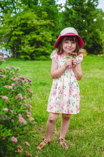 Kleines Mädchen mit Blumen in der Hand