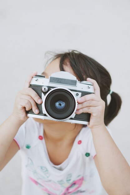 Kleines Mädchen mit einem alten Fotokamera