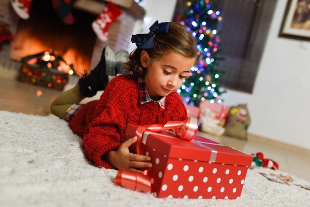 Kleines Mädchen mit einem roten Geschenk suchen