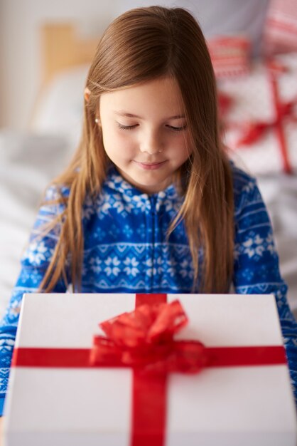 Kleines Mädchen mit großem Weihnachtsgeschenk