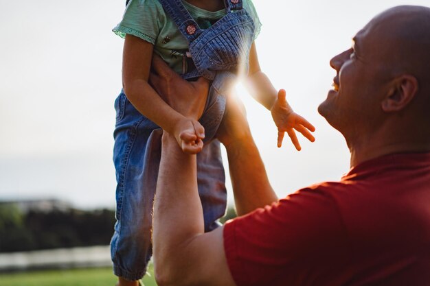 Kleines Mädchen mit Papa. Vater wirft Baby in die Luft. fröhliches Lachen, emotionales Kind, Glück.