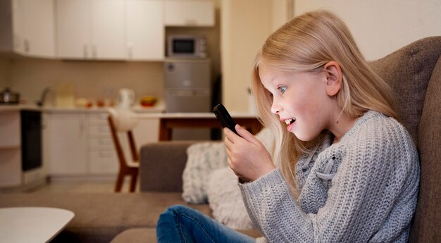 Kleines Mädchen mit Smartphone zu Hause