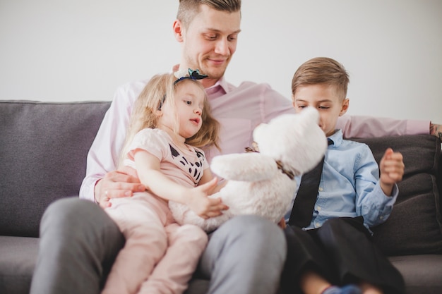 Kostenloses Foto kleines mädchen mit teddybär sitzt auf ihrem vater