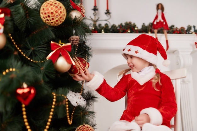 Kleines Mädchen Weihnachtsbaum beobachten