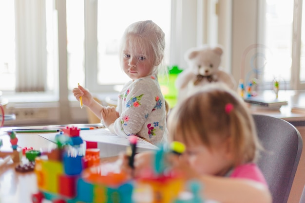 Kostenloses Foto kleines mädchen zeichnung sitzt am tisch