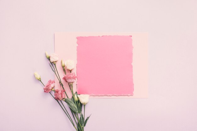 Kleines Papier mit rosafarbenen Blumen auf Tabelle