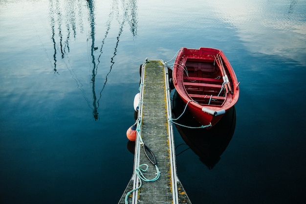 Kleines rotes Fischerboot auf einem Minihafen