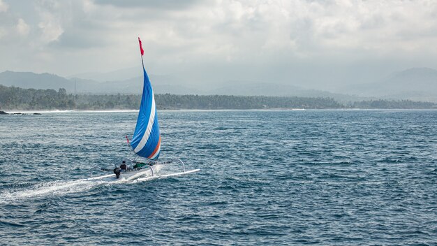 Kleines Segelboot schwimmt auf dem Wasser mit herrlichem Bergblick.