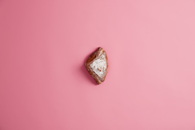 Kleines süßes frisches weich gebackenes Brötchen funkelte mit Zucker, lokalisiert auf rosa Hintergrund. Süßwaren backen. Leckeres Dessert zum Frühstück oder Abendessen. Ungesundes Essen, Lebensmittel mit vielen Kalorien