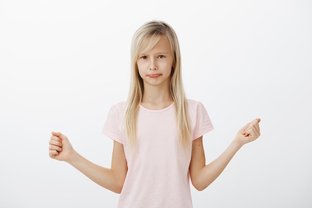 Kleines trauriges Mädchen, das aufgab, konnte keinen Kuchen backen. Innenaufnahme eines düsteren, unzufriedenen, entzückenden weiblichen Kindes in rosa Outfit