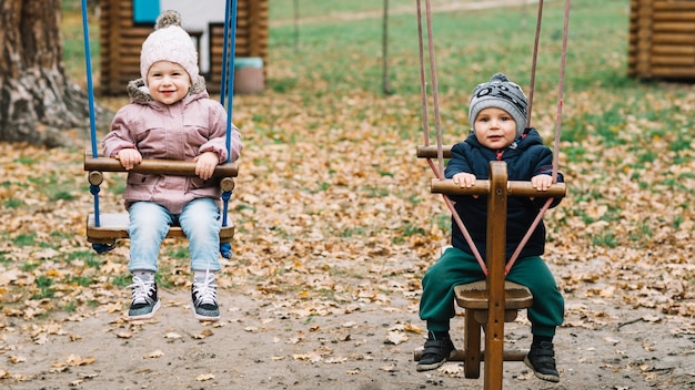 Kleinkindkinder, die auf hölzerner Wippe schwingen