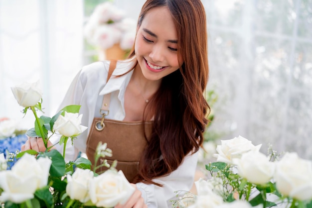 Kleinunternehmen Asien Weibliches Floristenlächeln, das Blumen im Blumengeschäft arrangiert Blumendesigngeschäft Glück lächelnde junge Dame, die Blumenvase für Kunden herstellt, die Blumenarbeiten von zu Hause aus vorbereiten