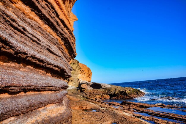 Klippen vor dem Wasser unter einem klaren blauen Himmel in Spanien