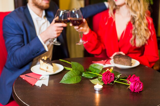 Klirrende Gläser der Paare bei Tisch im Restaurant