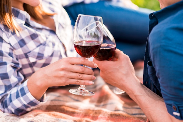 Klirrende Gläser des Mannes und der Frau auf Picknick