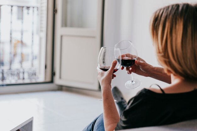 Klirrender Wein der Paare auf Couch