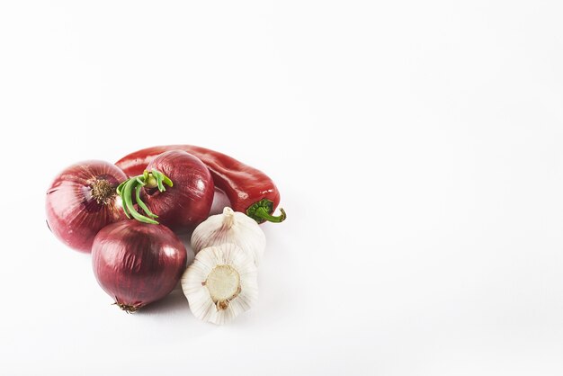 Knoblauch der blauen Zwiebel und scharfer roter Pfeffer lokalisiert auf Weiß.