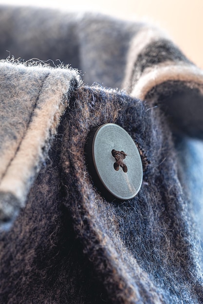 Knopf auf einem Makroschuß des warmen blauen Hemdes