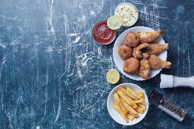 Knusprige Hähnchenschenkel mit Nuggets und Kartoffeln.