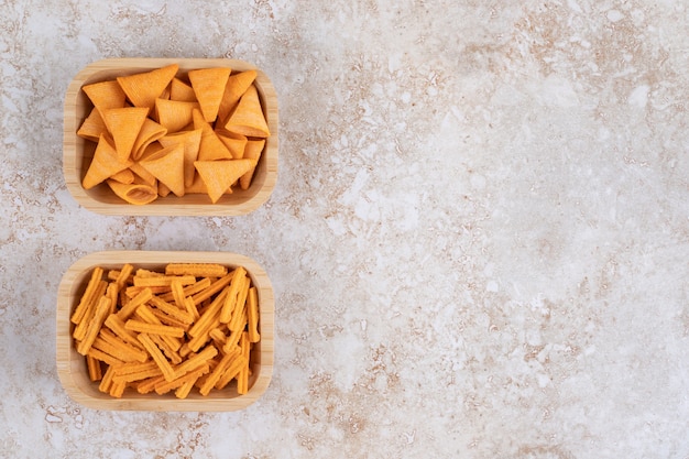 Knusprige Kegelchips und Crouton in Schalen auf dem Marmortisch.