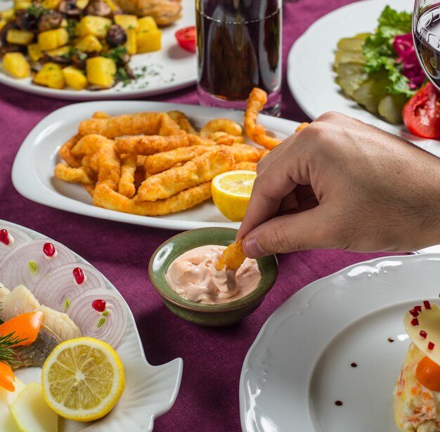 Knusprige Snacksticks in weiße Sahnesauce eintauchen.