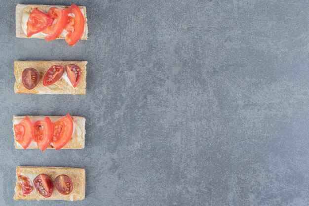 Knusprige Toasts mit Tomaten auf Marmor.