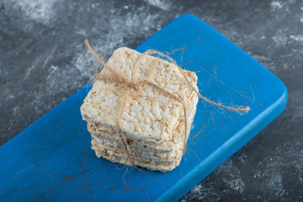 Knuspriges brot im seil auf einem hölzernen schneidebrett.