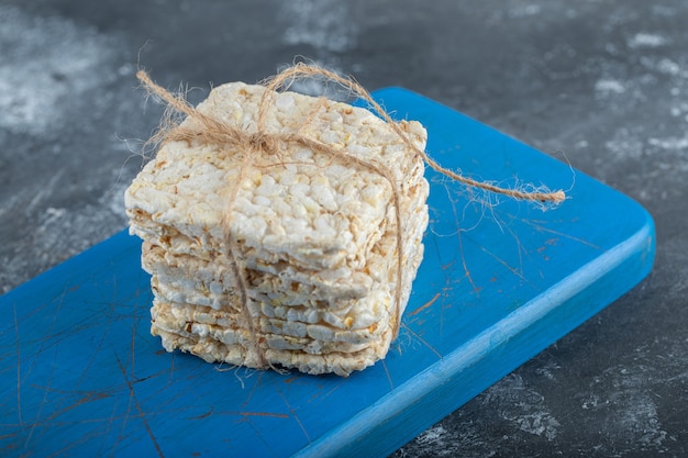 Kostenloses Foto knuspriges brot im seil auf einem hölzernen schneidebrett.