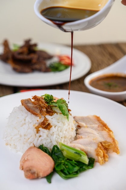 Knuspriges Schweinefleisch auf einem weißen Teller mit Sauce.