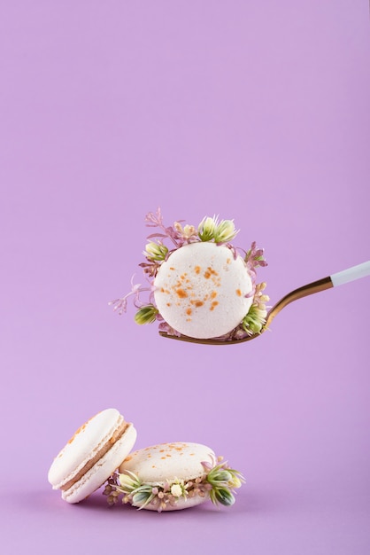 Öko-Macarons mit Blumen auf lila Hintergrund