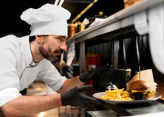 Kostenloses Foto koch kocht in der küche und trägt professionelle kleidung