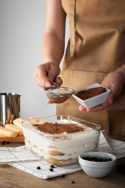 Koch mit seitlicher Ansicht, der Tiramisu zubereitet