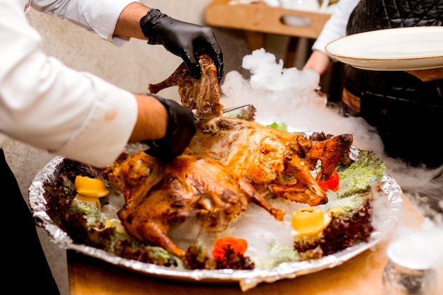 Koch schneidet gegrilltes Hähnchen