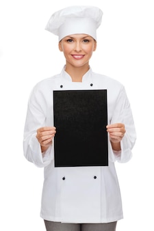 Koch-, werbe- und lebensmittelkonzept - lächelnde köchin, köchin oder bäckerin mit leerem schwarzem papier