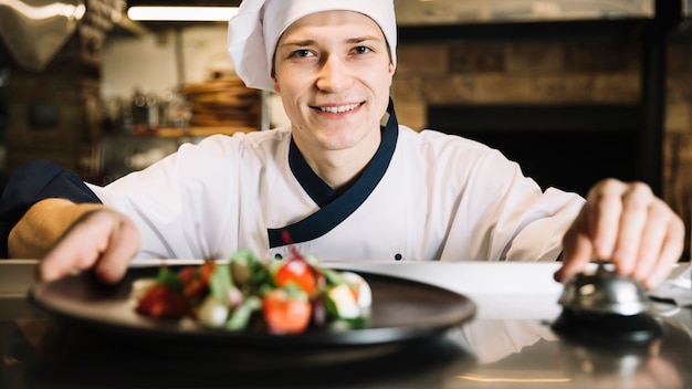 Kostenloses Foto kochen sie mit salat auf klingel-service-glocke