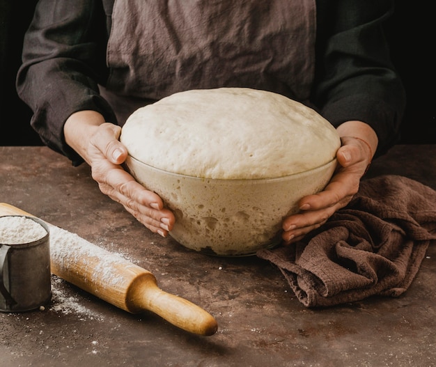 Köchin, die Schüssel mit Pizzateig hält